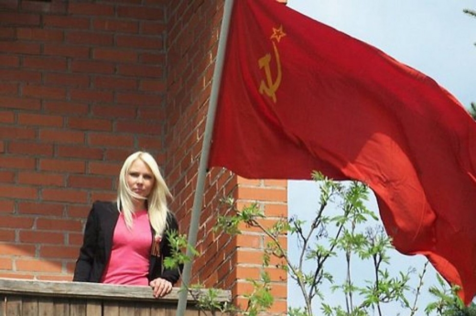 Osipova sieva pie savas mājas Liepājā izkar PSRS karogu